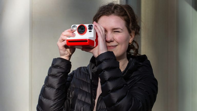 Eine Person schaut durch eine Polaroid-Kamera.