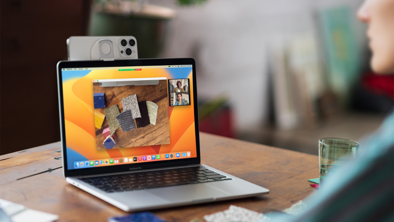 Ein iPhone 13 Pro klemmt am oberen Rand eines MacBooks und fungiert als dessen Webcam.