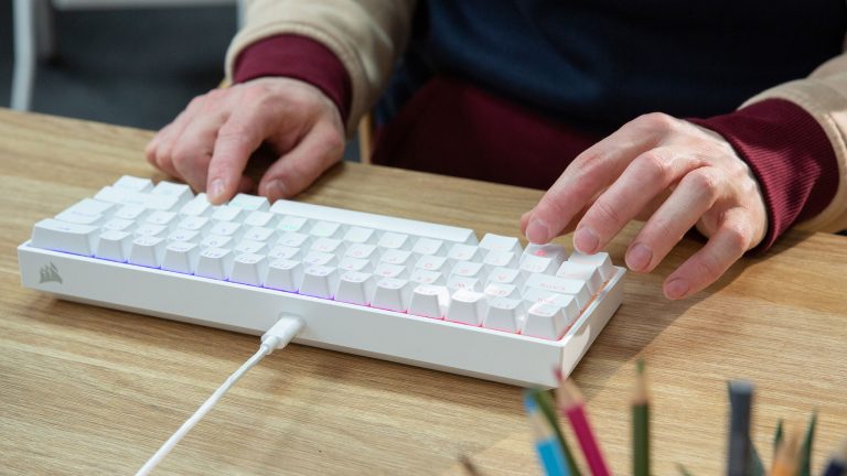 Eine Person tippt auf einer Corsair K65 Mini.
