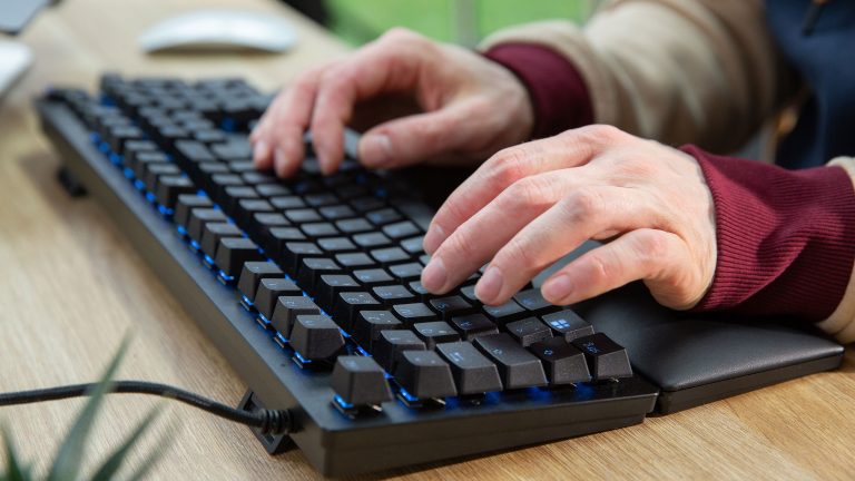 Eine Person tippt auf einer Huntsman V2 von Razer. Zu erkennen sind die hochstehenden Tasten.