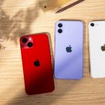 Auf einem Tisch liegen mit der R&uuml;ckseite nach oben iPhone 13, iPhone 12 und iPhone SE.