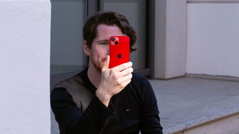 Eine Person hält das iPhone 13 vor ihrem Gesicht.