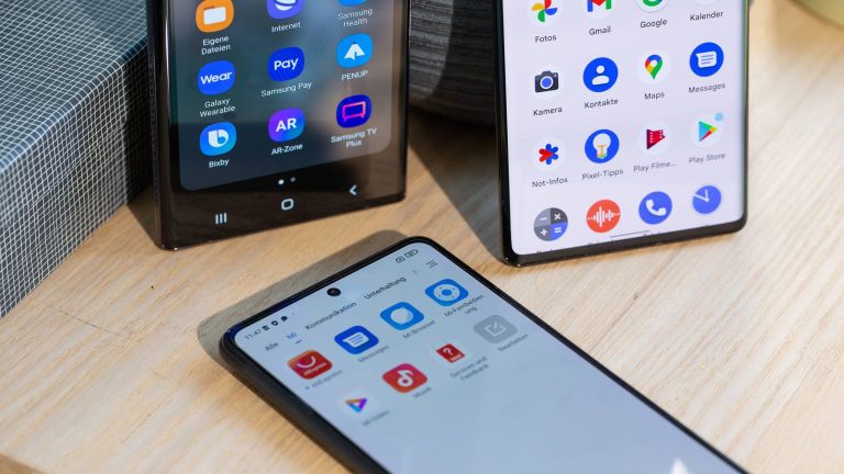 Detailansicht der Smartphones Samsung Galaxy S22 Ultra, Google Pixel 6 Pro und einXiaomi Mi 10T auf einem Regal.