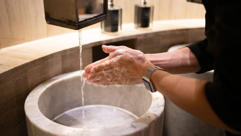Eine Person wäscht sich die Hände. Am Handgelenk sitzt eine Apple Watch.