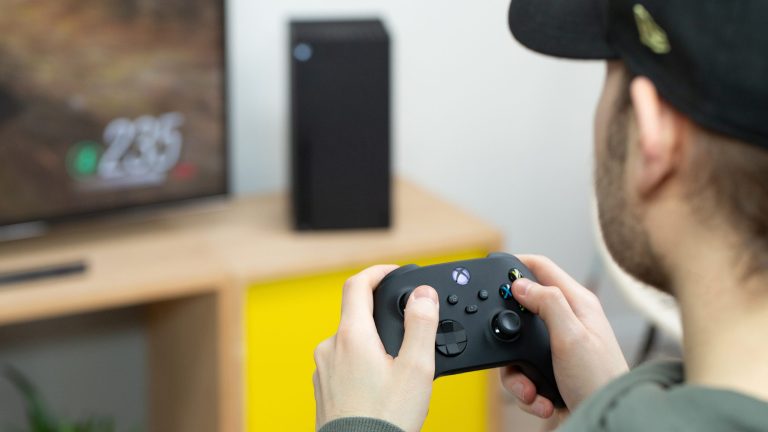 Eine Person hält einen Xbox-Controller in der Hand und spielt auf einer Xbox Series X.
