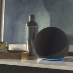 Ein Echo Dot steht auf einem Sideboard neben einigen Gl&auml;sern und einem Cocktailshaker.