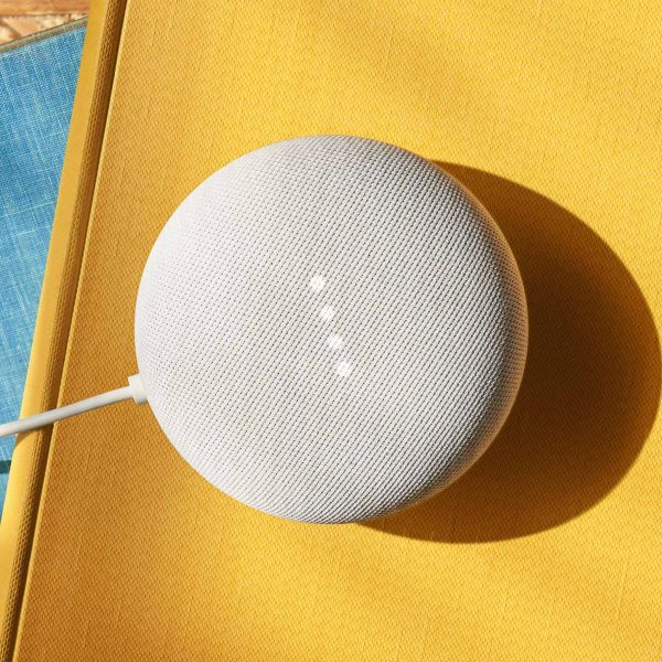 Ein Google Nest Mini steht auf einer gelben Oberfl&auml;che.
