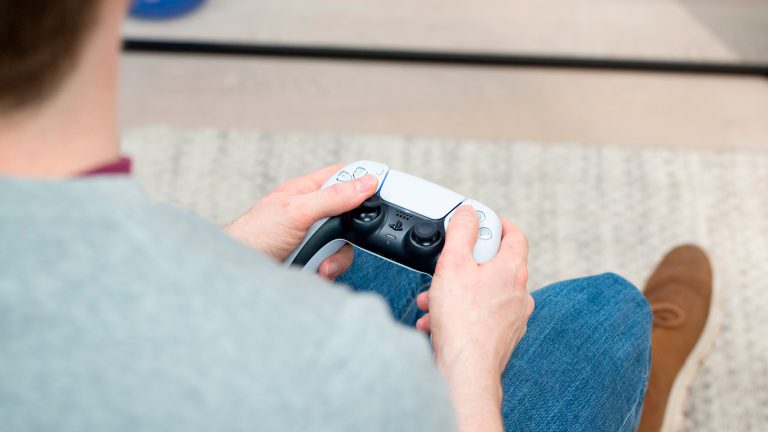 Eine Person hält den DualSense Controller der PlayStation 5 in den Händen.