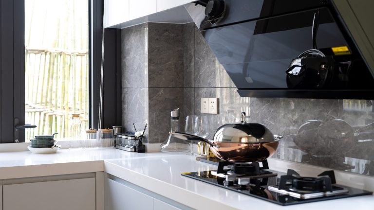Über einem Gasherd ist eine kopffreie Dunstabzugshaube montiert.