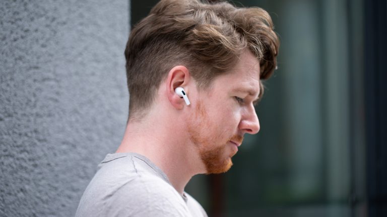 Eine Person im Profil hat einen AirPod-Pro-Kopfhörer im rechten Ohr stecken.