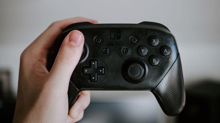 Nintendo Switch Pro Controller Eine Person hält einen Pro Controller für die Nintendo Switch in der Hand.