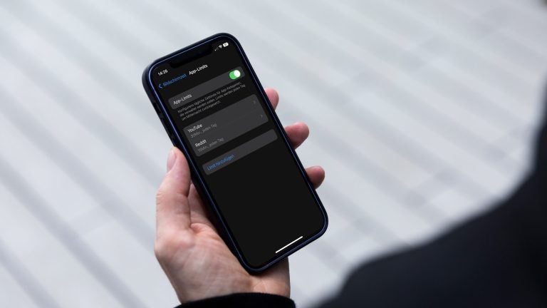 Eine Person schaut auf ihr iPhone, darauf sind die Einstellungen f&uuml;r App-Limits zu sehen.