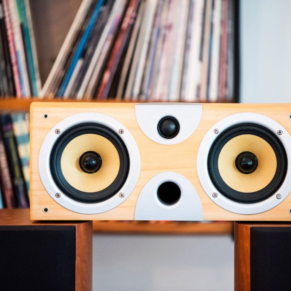 Eine Subwoofer-Box ohne Abdeckung steht auf zwei Regallautsprechern.