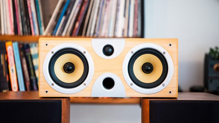 Eine Subwoofer-Box ohne Abdeckung steht auf zwei Regallautsprechern.