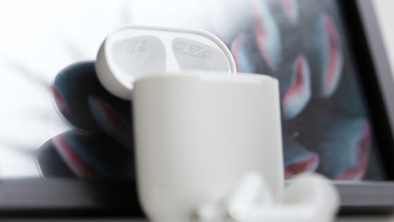 Apple Seriennummer Bild von weißen AirPods die an einen Bilderrahmen gelehnt sind.