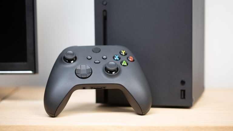 Ein Xbox Wireless Controller ist an eine Xbox Series X gelehnt.