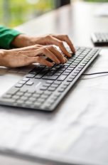 Eine Person tippt auf einer Tastatur, die an einen Rechner angeschlossen ist. Tastatur gesperrt