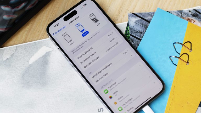 Ein iPhone liegt auf einem Stapel Zettel und Postkarten. Auf dem Display sind die Mitteilungsoptionen zu sehen. Ein iPhone liegt auf einem Stapel Zettel und Postkarten. Auf dem Display sind die Mitteilungsoptionen zu sehen.