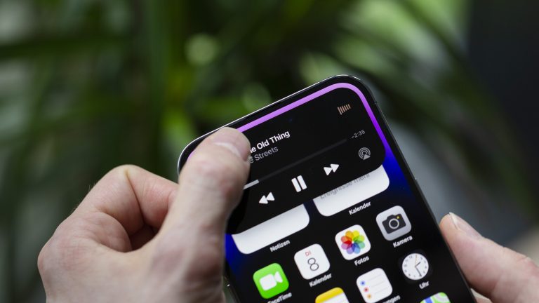 Dynamic Island Eine Person hält ihren Finger auf die Dynamic Island und öffnet so die Wiedergabe-Einstellungen einer App.