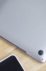 Ein umgedrehtes MacBook liegt auf einem Tisch. Zu sehen sind die schmalen Lüftungsschlitze.
