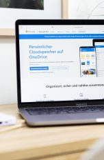 OneDrive synchronisiert nicht: So löst du das Problem Ein MacBook Pro mit geöffneter OneDrive-Produktseite steht auf einem Tisch.