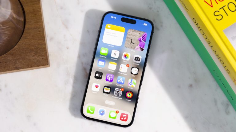 Ein iPhone 14 Pro mit eingeschaltetem Display liegt auf einem Marmor-Untergrund.