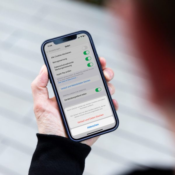 Eine Person h&auml;lt ein iPhone in den H&auml;nden. Darauf sind die Einstellungen zu sehen, in denen sich der Browser-Cache leeren l&auml;sst.