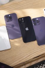 Auf einem Regal liegen mehrere aktuelle iPhones nebeneinander.