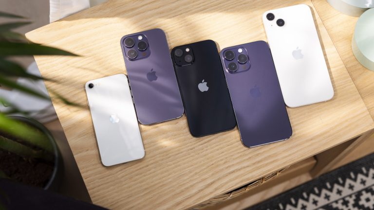 Auf einem Regal liegen mehrere aktuelle iPhones nebeneinander.
