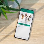 Ein Smartphone, auf dem WhatsApp ge&ouml;ffnet ist, liegt auf einem Holztisch.