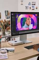 Eine Person sitzt vor einem Mac mini und bearbeitet ein Bild.