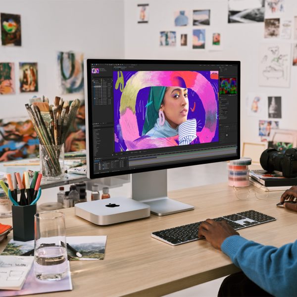 Eine Person sitzt vor einem Mac mini und bearbeitet ein Bild.