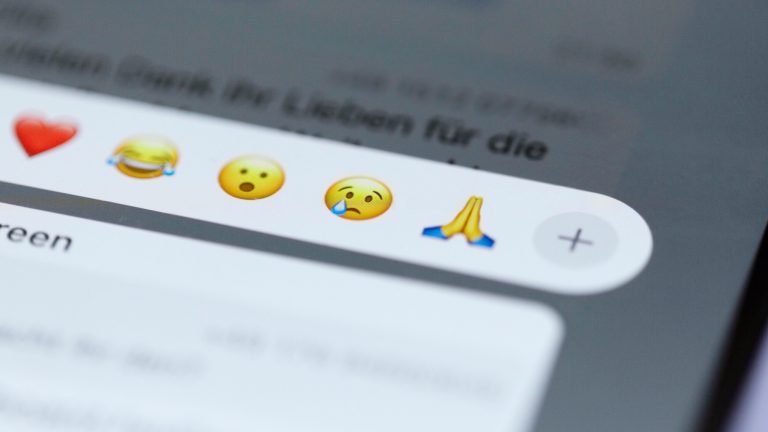 Screenshot eines WhatsApp-Chats, in dem gerade die Emoji-Reaktionen auf eine Nachricht geöffnet sind.