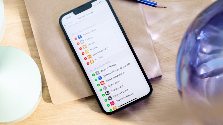 Ein iPhone liegt auf einem Tisch. Auf dem Display sind die Kontrollzentrum-Einstellungen zu sehen.