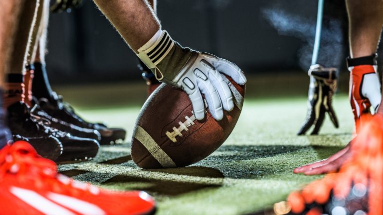 Nahaufnahme eines Footballs an der Line of Scrimmage.