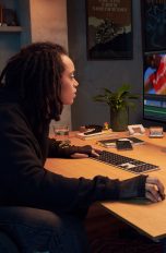 Eine Person sitzt an einem Schreibtisch vor einem Apple Studio Display. Eine Person sitzt an einem Schreibtisch vor einem Apple Studio Display.