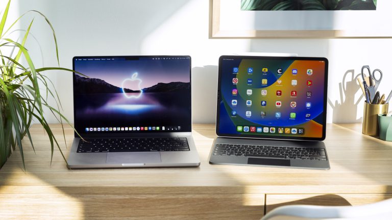 Ein MacBook Pro und ein iPad Pro stehen nebeneinander auf einem Tisch.