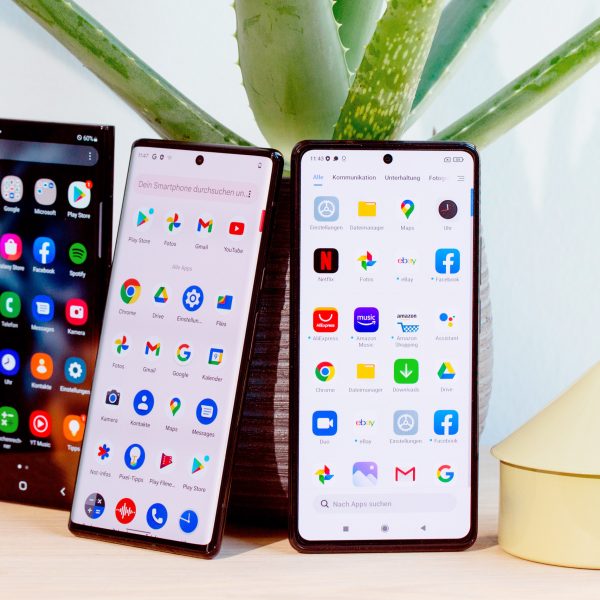Drei Android-Smartphones stehen nebeneinander auf einem Tisch.