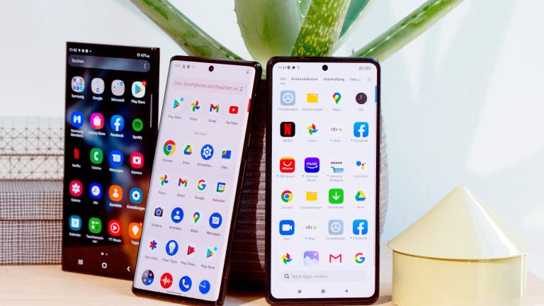 Drei Android-Smartphones stehen nebeneinander auf einem Tisch.