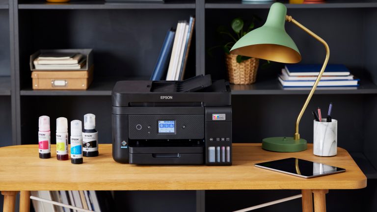 Ein Epson Ecotank-Drucker mitsamt nachfüll-Flaschen steht auf einem Schreibtisch.