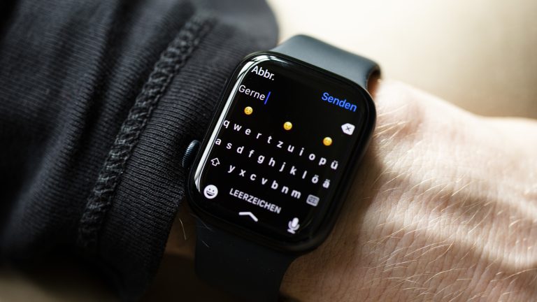 Nahaufnahme einer Apple Watch, auf der gerade die Tastatur zum Tippen einer Antwort auf eine WhatsApp-Nachricht zu sehen ist.
