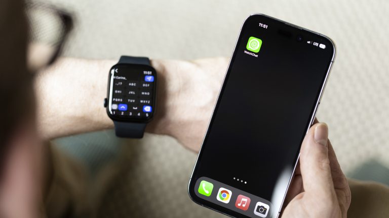 Eine Person hält ihr iPhone neben ihre Apple Watch. Auf dem iPhone ist der Homescreen samt WatchChat-2-App zu sehen. Auf der Apple Watch ist selbige App geöffnet. Diese zeigt ein Antwortfenster für eine WhatsApp-Nachricht.