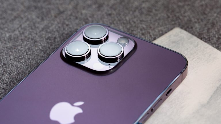 Ein iPhone liegt mit der R&uuml;ckseite nach oben auf einem Sofa.