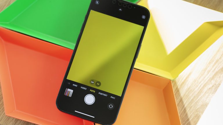 Ein iPhone mit ge&ouml;ffneter Kamera-App liegt auf bunten Schalen.