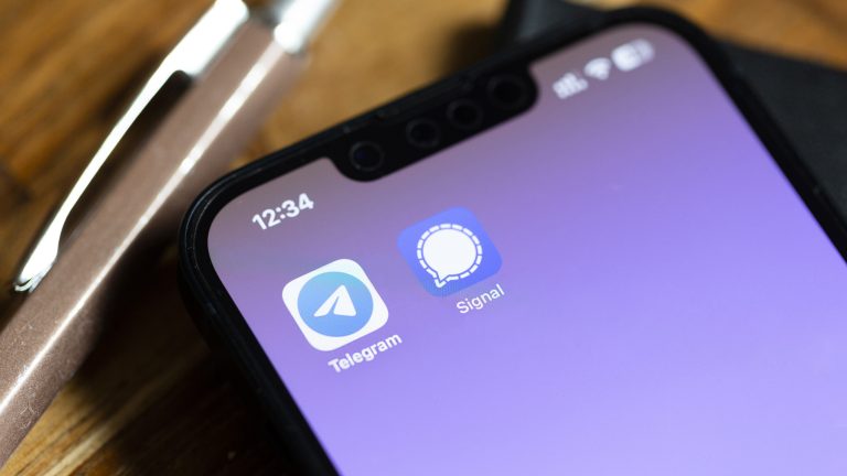 Blick auf ein iPhone, auf dessen Screen die Apps von Telegram und Signal zu sehen sind.