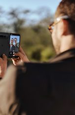 Zwei Personen fertigen mit einem Google Pixel Fold ein Selfie an.