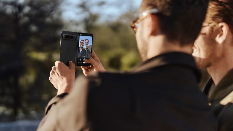 Zwei Personen fertigen mit einem Google Pixel Fold ein Selfie an.
