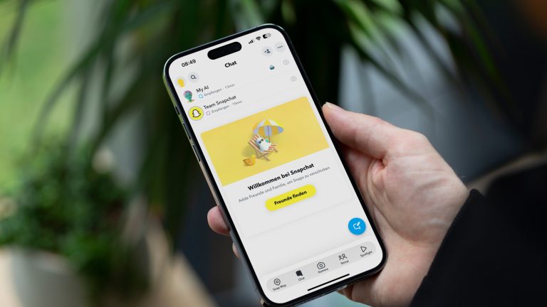 Eine Person h&auml;lt ein iPhone 14 Pro Max in der Hand, auf dem die Chats von Snapchat zu sehen sind. MyAI steht dabei ganz oben.