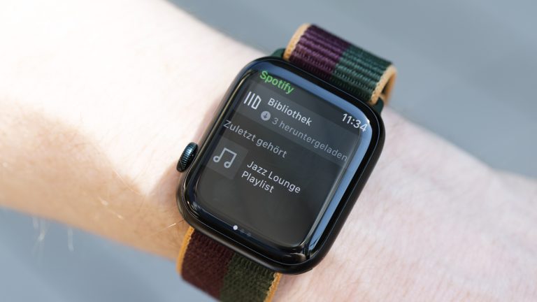 Nahaufnahme einer Apple Watch 8, auf der die Spotify-Bibliothek auf drei heruntergeladene Medien hinweist.