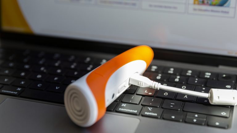 Ein Tiptoi-Stift ist über ein Kabel mit einem Macbook verbunden. Darauf ist der Tiptoi-Manager geöffnet.